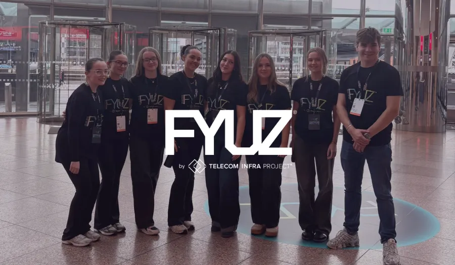 FYUZ by Telecom Infra Project logo over the event crew in branded shirts at a venue entrance