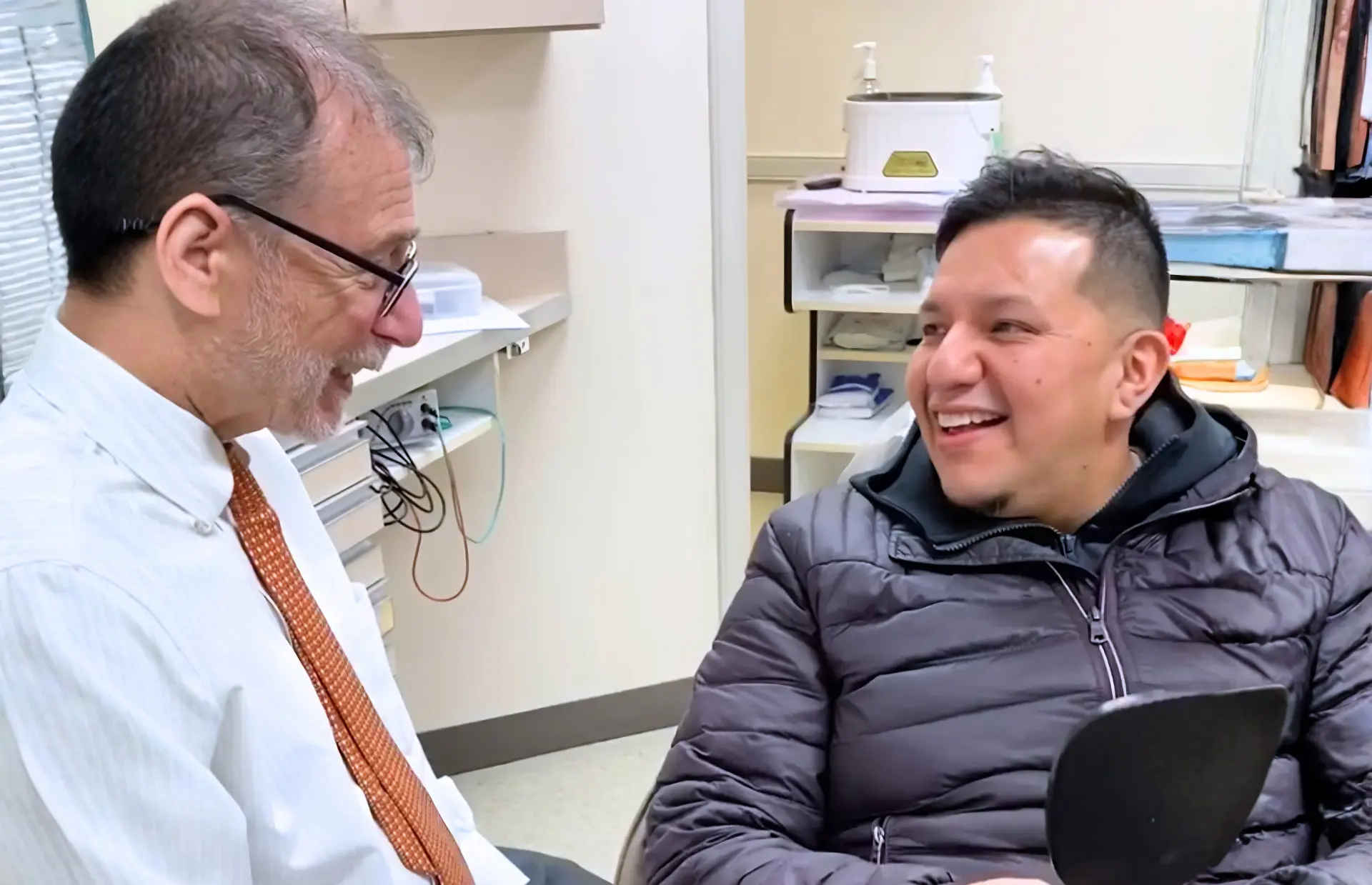 Dental Care Stamford dentist sharing a finished smile reveal with a happy patient after cosmetic dental treatment.