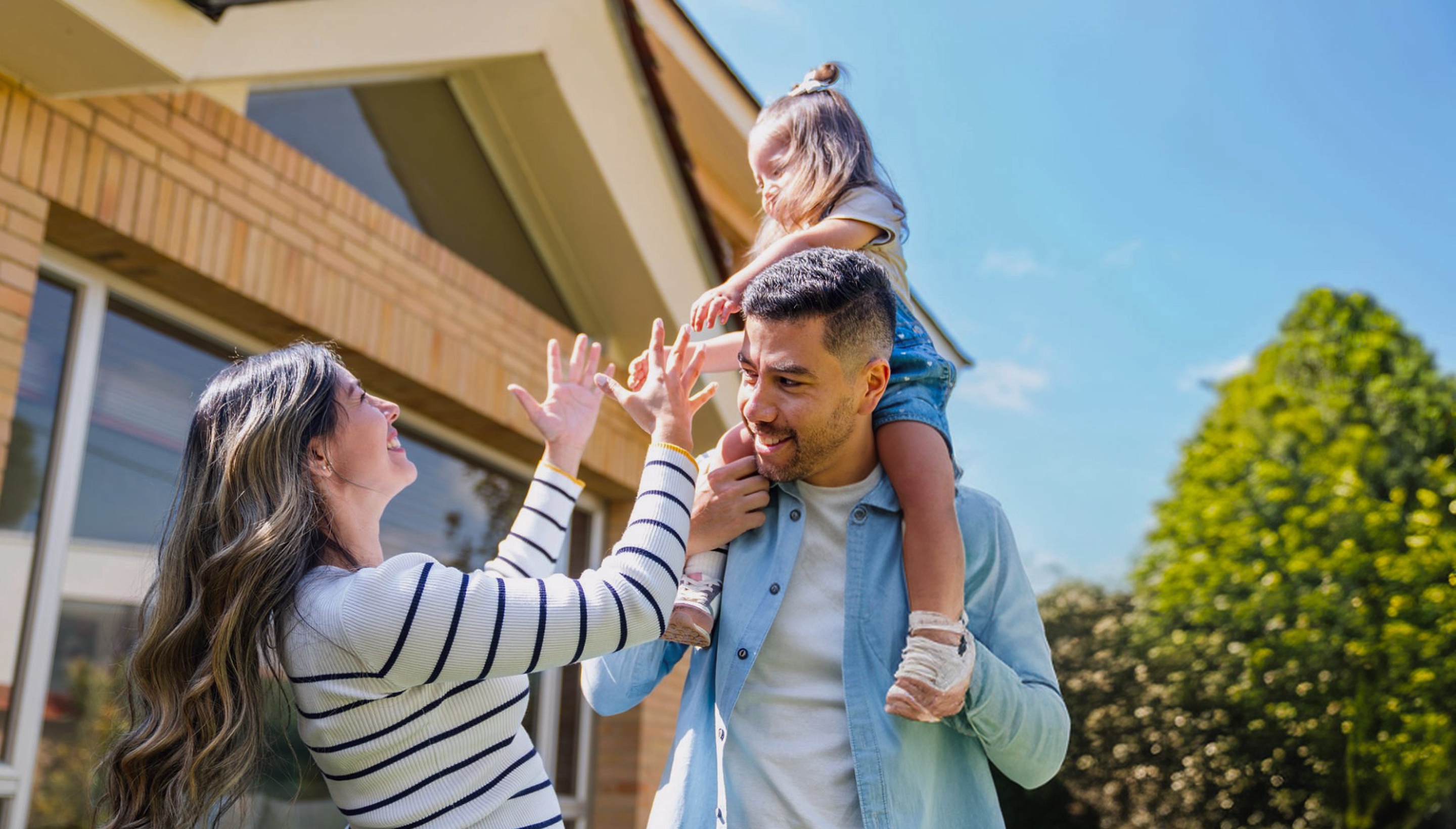 Hero image of family playing outside in front of their house