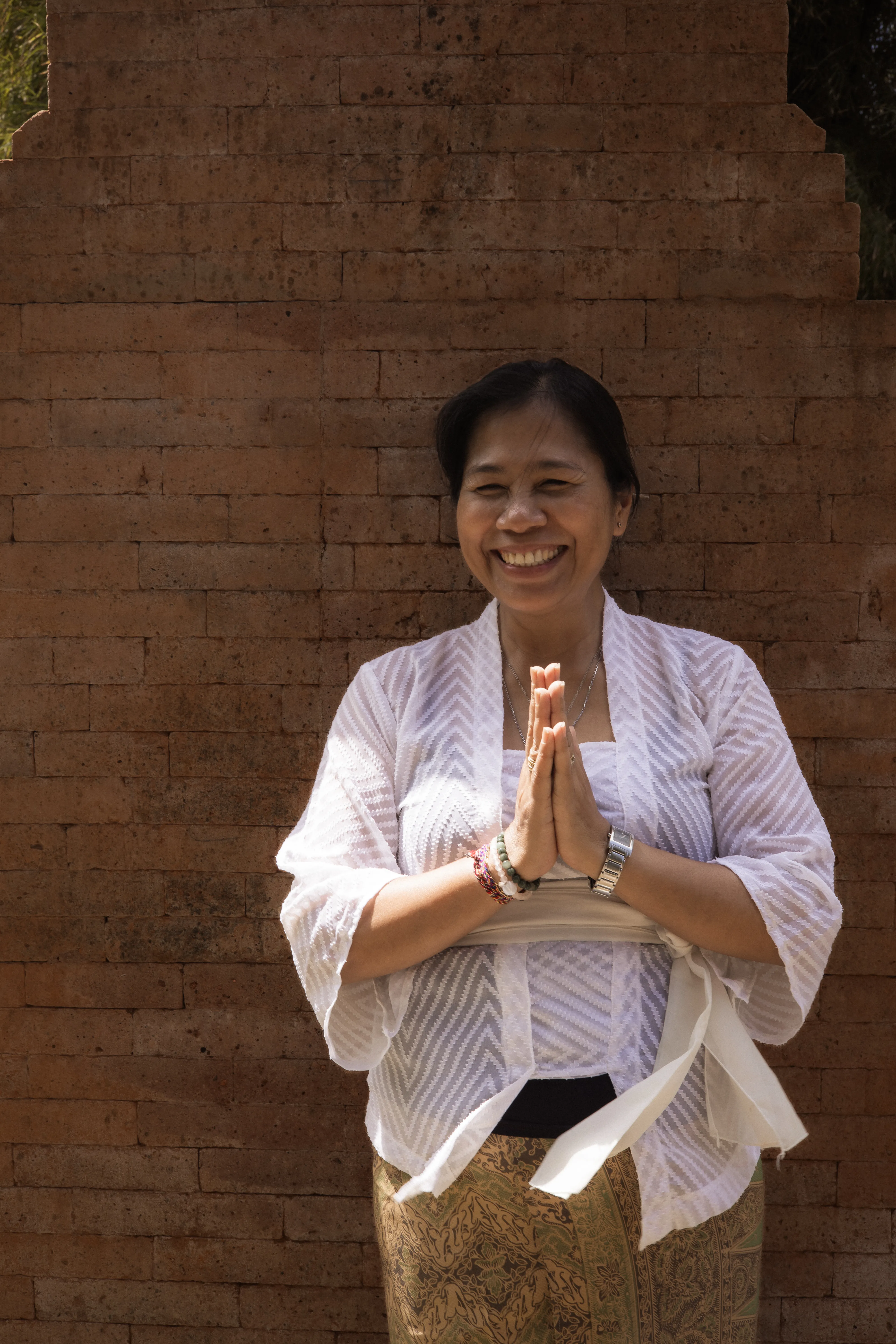Ibu Jero Made sharing a traditional Balinese daily offering ritual with retreat guests at Balquisse Heritage Hotel Jimbaran
