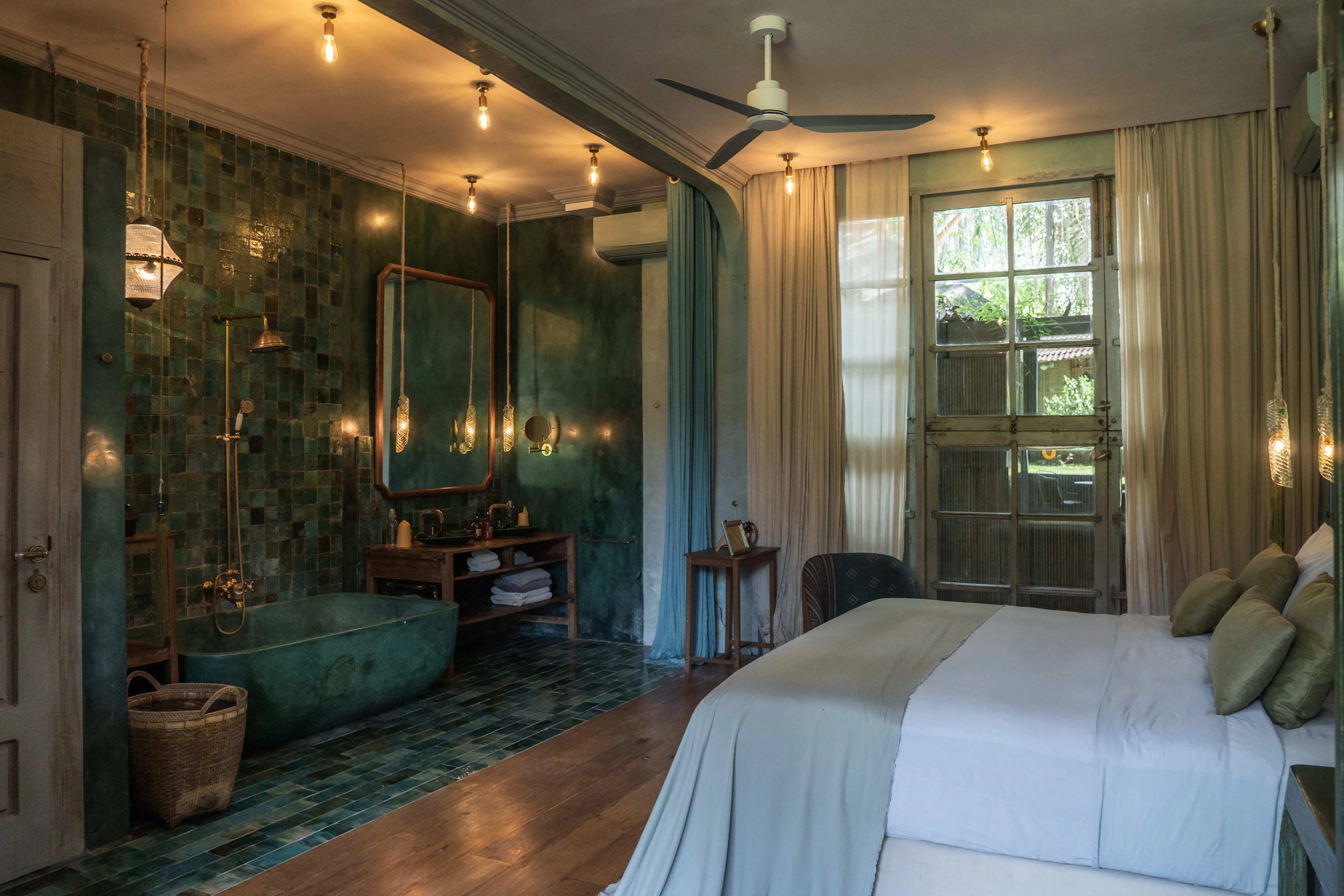Elegant boutique bedroom suite with green tiled bathroom and freestanding bathtub at The Shaba Shala.