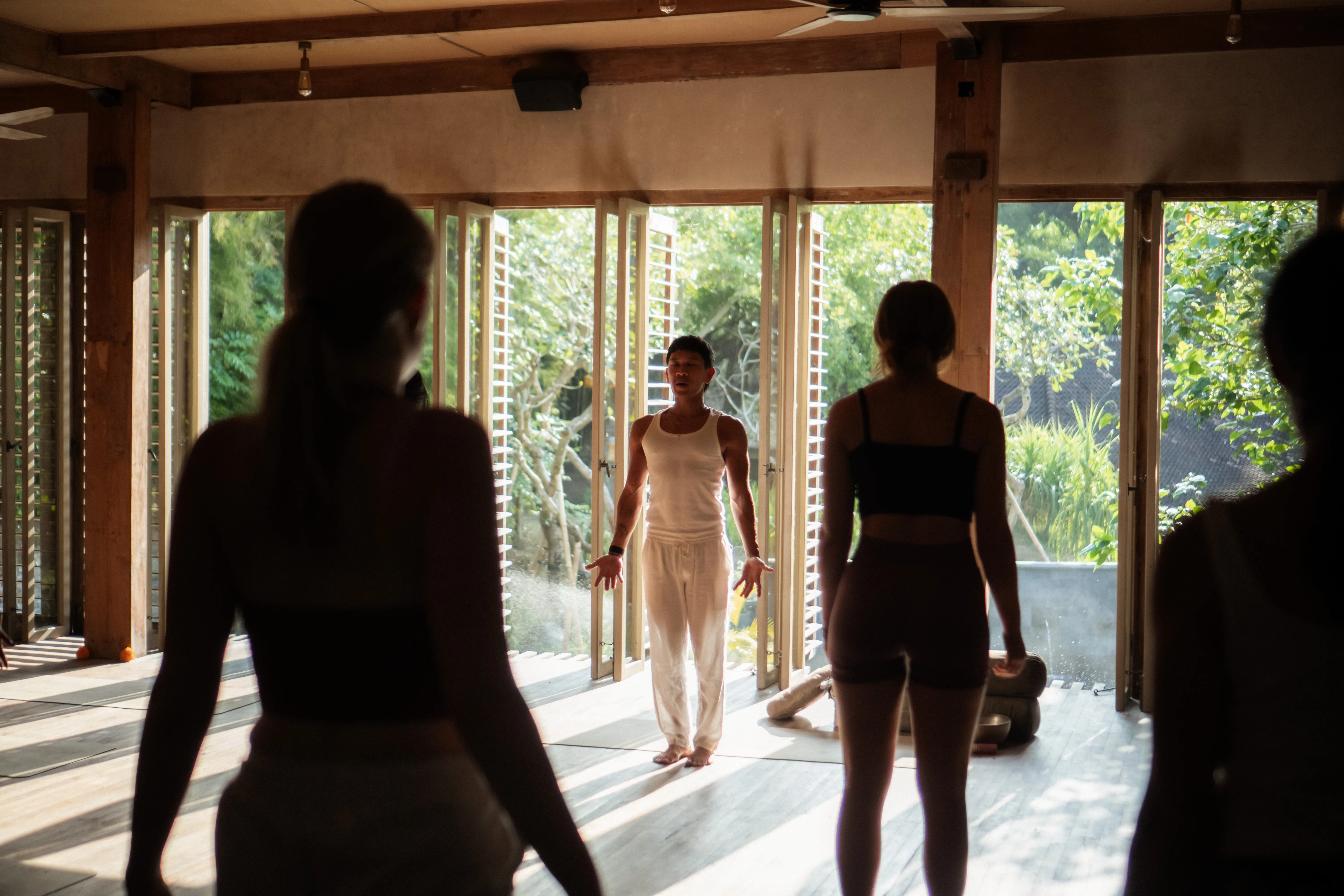 Yoga instructor leading a meditation class inside the open-air wooden shala at The Shaba Shala.