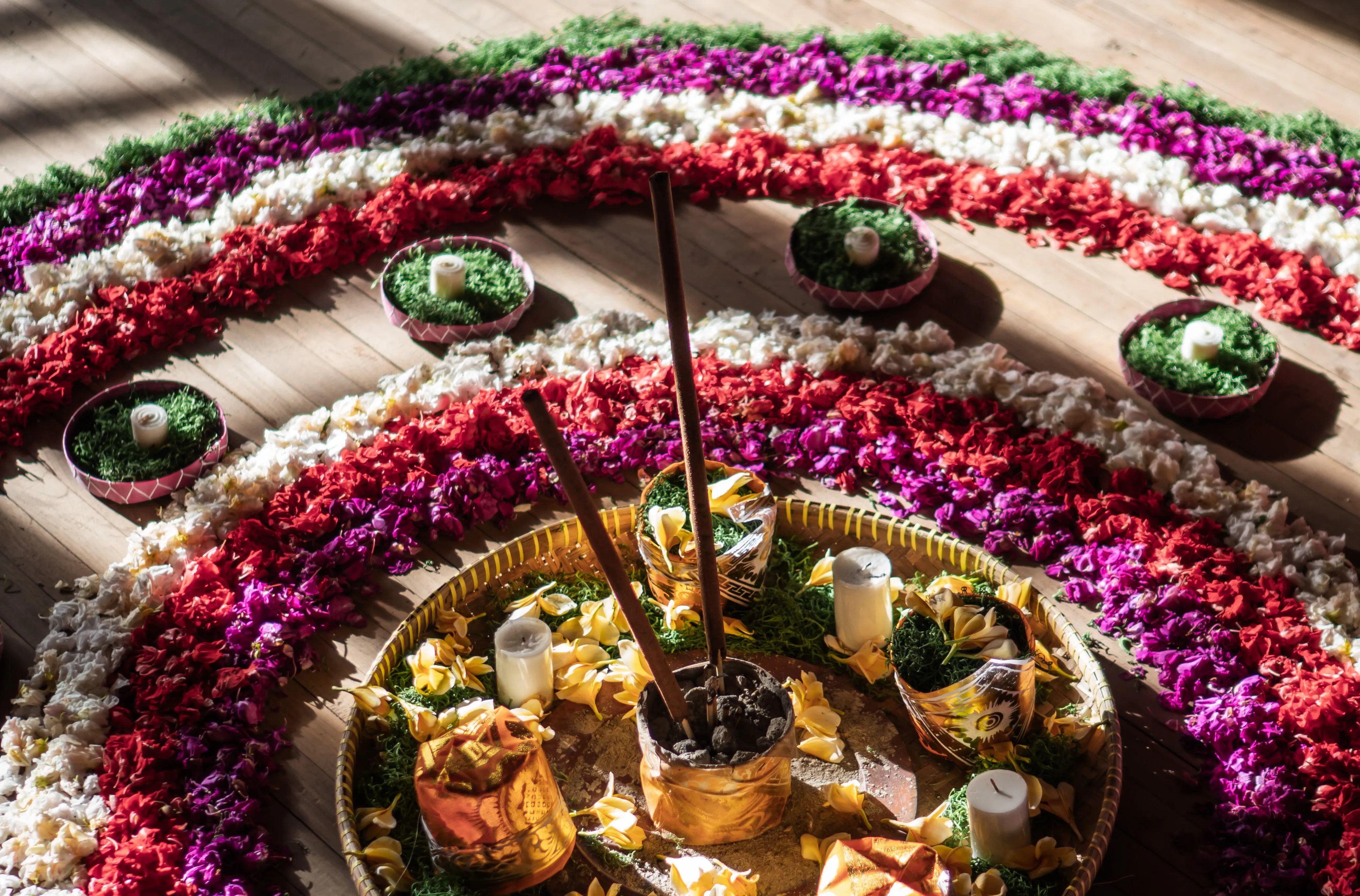 Concentric arrangement of colorful flower petals and burning incense sticks for a spiritual ritual at The Shaba Shala.