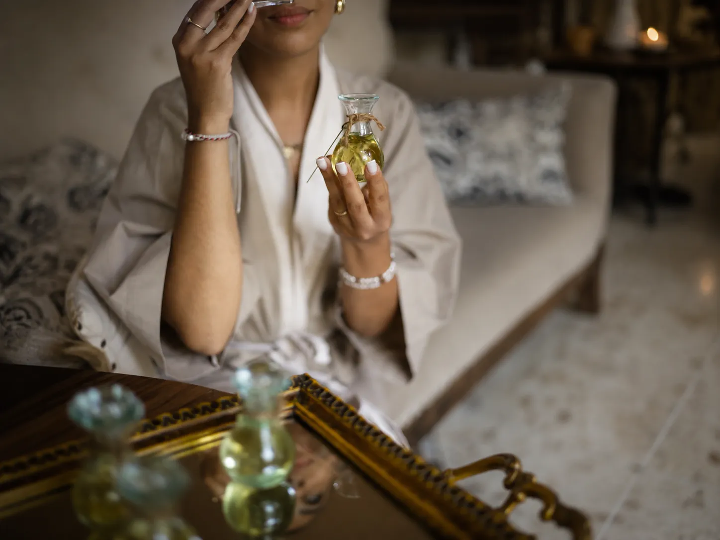 Woman wearing a bathrobe holding a small glass bottle of aromatherapy essential oil at The Shaba Shala.