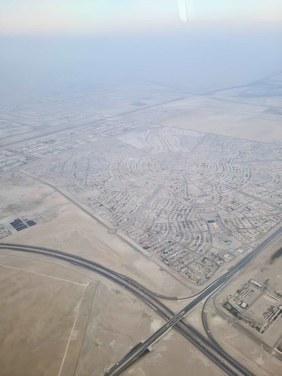 Aerial view of a abu dhabi city with circular neighborhood layout and intersecting highways.