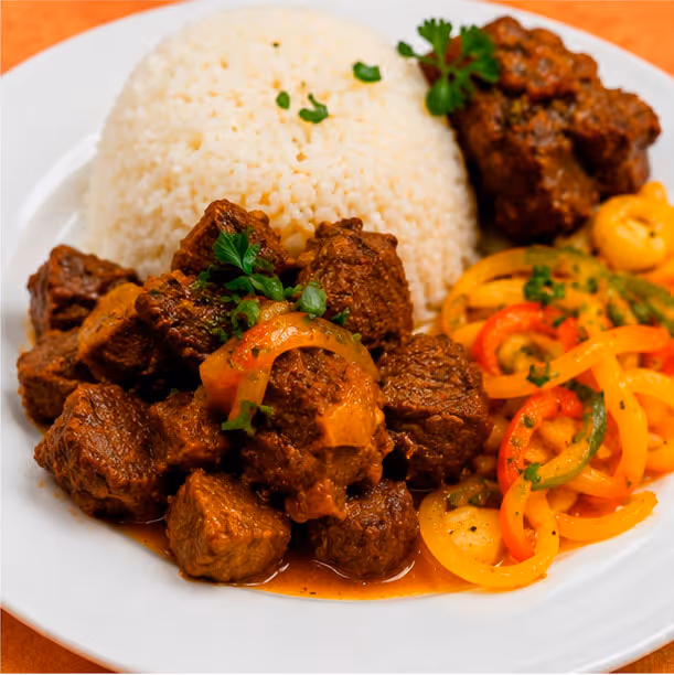 A dish containing carne, rice, and assorted vegetables, with a side of vibrant peppers for added flavor.