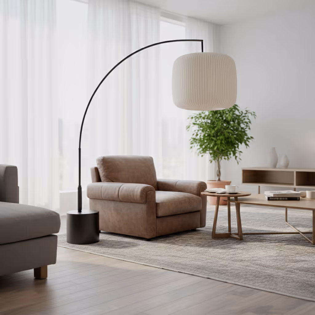 Modern living room with a brown armchair under a curved black floor lamp, light wood coffee tables, a green potted plant, and sheer white curtains.