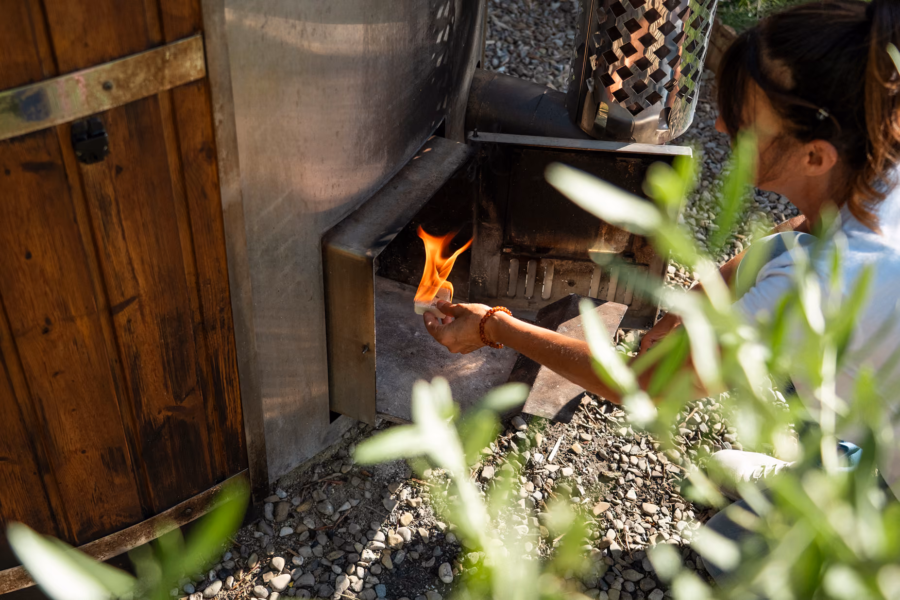 Accensione del fuoco a legna per scaldare la hot tub (jacuzzi o bagno caldo) fuori dalle yurte al Glamping per coppie Due cuori e una Yurta