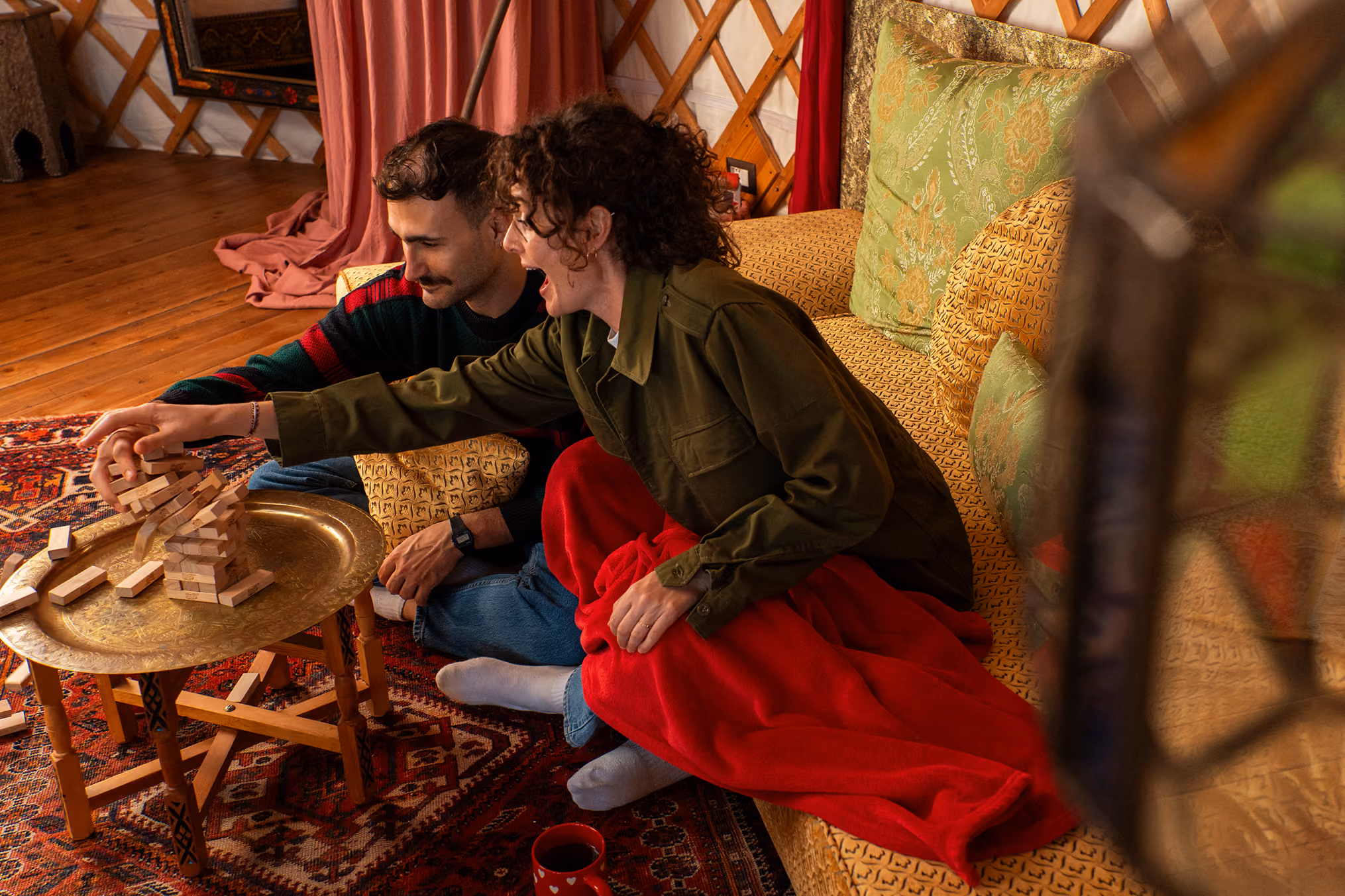 Una coppia fa giochi di società dentro una yurta in inverno al Glamping per coppie Due cuori e una Yurta
