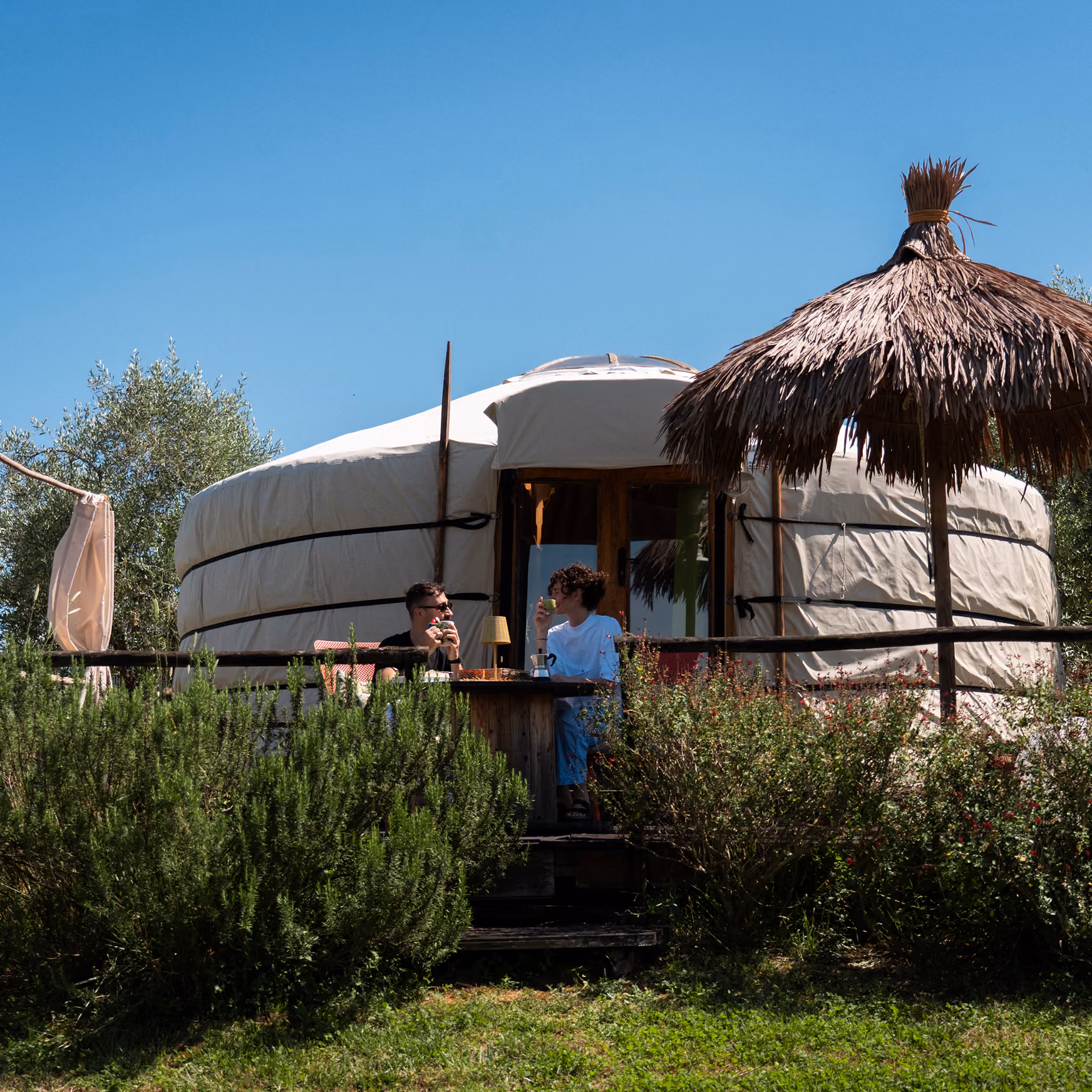 Una coppia fa colazione nel giardino fuori dalla propria yurta al Glamping per coppie Due cuori e una Yurta