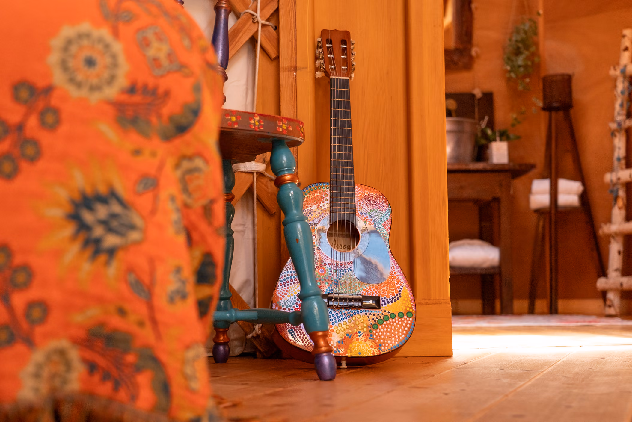 Foto di dettaglio di una chitarra dipinta a mano al Glamping per coppie Due cuori e una Yurta. In ogni yurta è presente uno strumento musicale