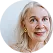 Smiling elderly woman with light hair against a white background.