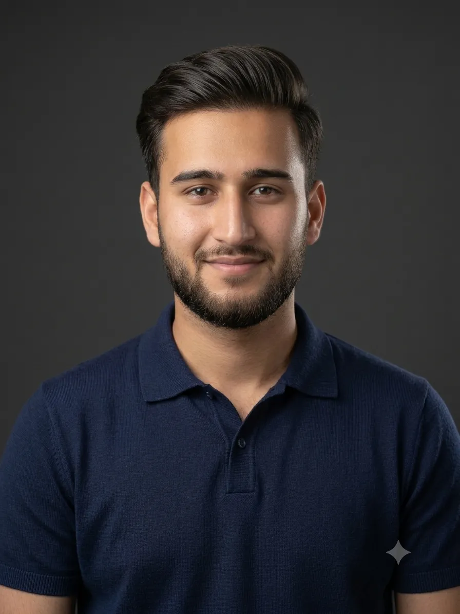 Portrait of a man with dark hair and beard wearing a navy blue polo shirt against an orange background.