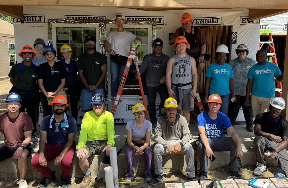 Smart Data Solutions volunteers in hard hats at a community home-build project