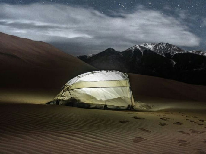 A lit desert dome lodge at night beneath mountains and cloud | Digital Engagement and Social Media, Cevalon