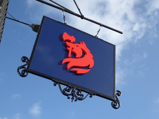 A Jackson-Stops hanging sign with the red horse emblem against a blue sky | Brand Identity and Digital Transformation, Jackson-Stops