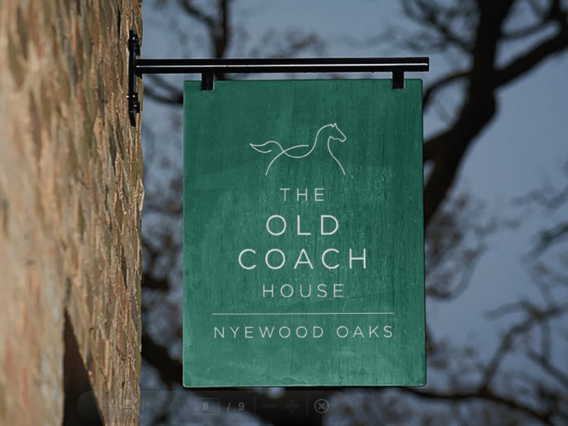 The Old Coach House hanging sign with its horse emblem on a brick wall | Hospitality Brand Identity, Nyewood Oaks