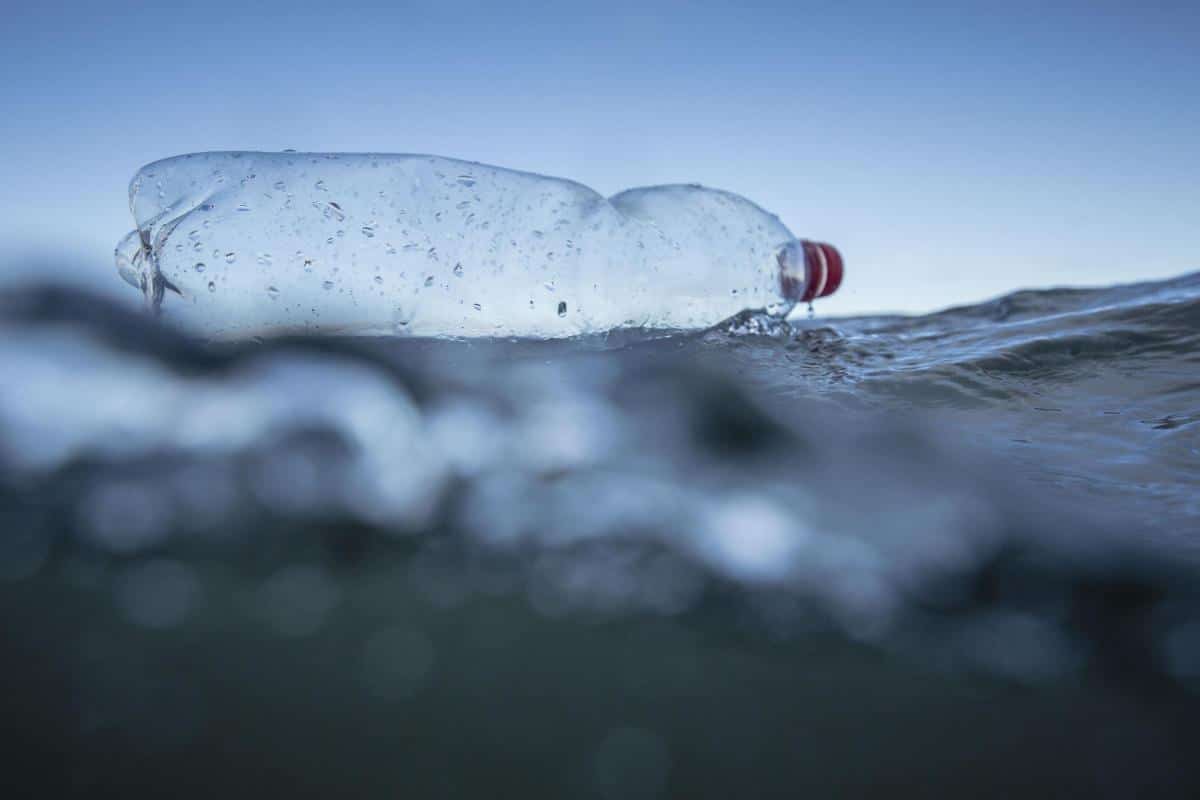 A discarded plastic bottle floating just below the surface of the sea.