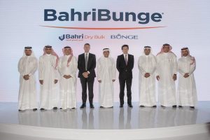 Executives on stage at the BahriBunge signing, standing beneath the joint venture's combined logo.