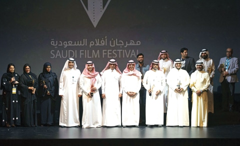 Filmmakers and organisers on stage at the Saudi Film Festival beneath the festival's Arabic and English signage.