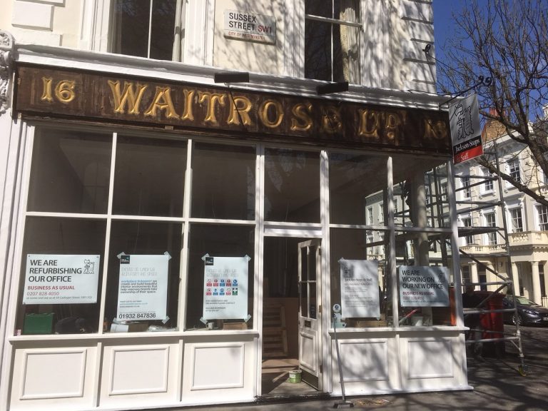 A Waitrose shopfront under refurbishment, with signage explaining that the branch remains open as usual.