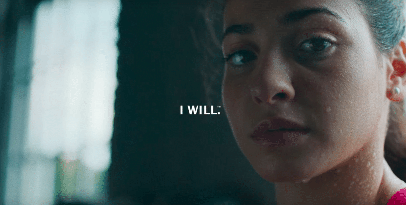 A close-up of a female athlete mid-effort with the caption I WILL, from a campaign on women in sport.