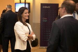 Guests in conversation beside an Iridium Advisors Close Gaps banner at the launch.
