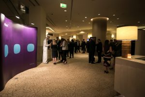 Guests arriving through a hotel foyer dressed with Iridium Advisors branding.