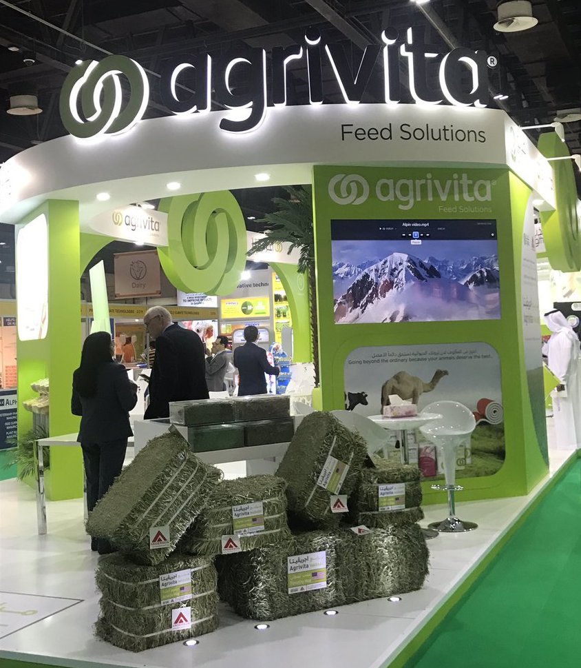 The Agrivita exhibition stand at a feed industry trade show, with product displays and branded bales of animal feed.