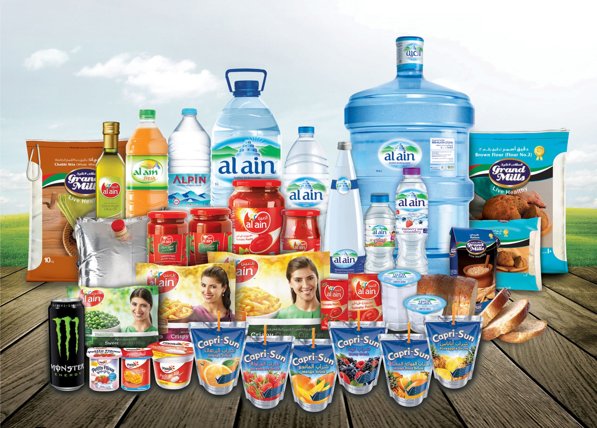 The Agthia group product range, including Al Ain water, juices, dairy and packaged foods arranged on a wooden surface.