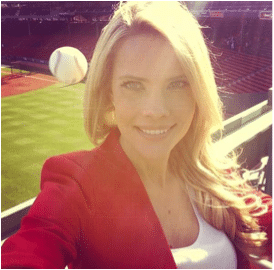 A woman taking a selfie in the stands at a sports stadium.