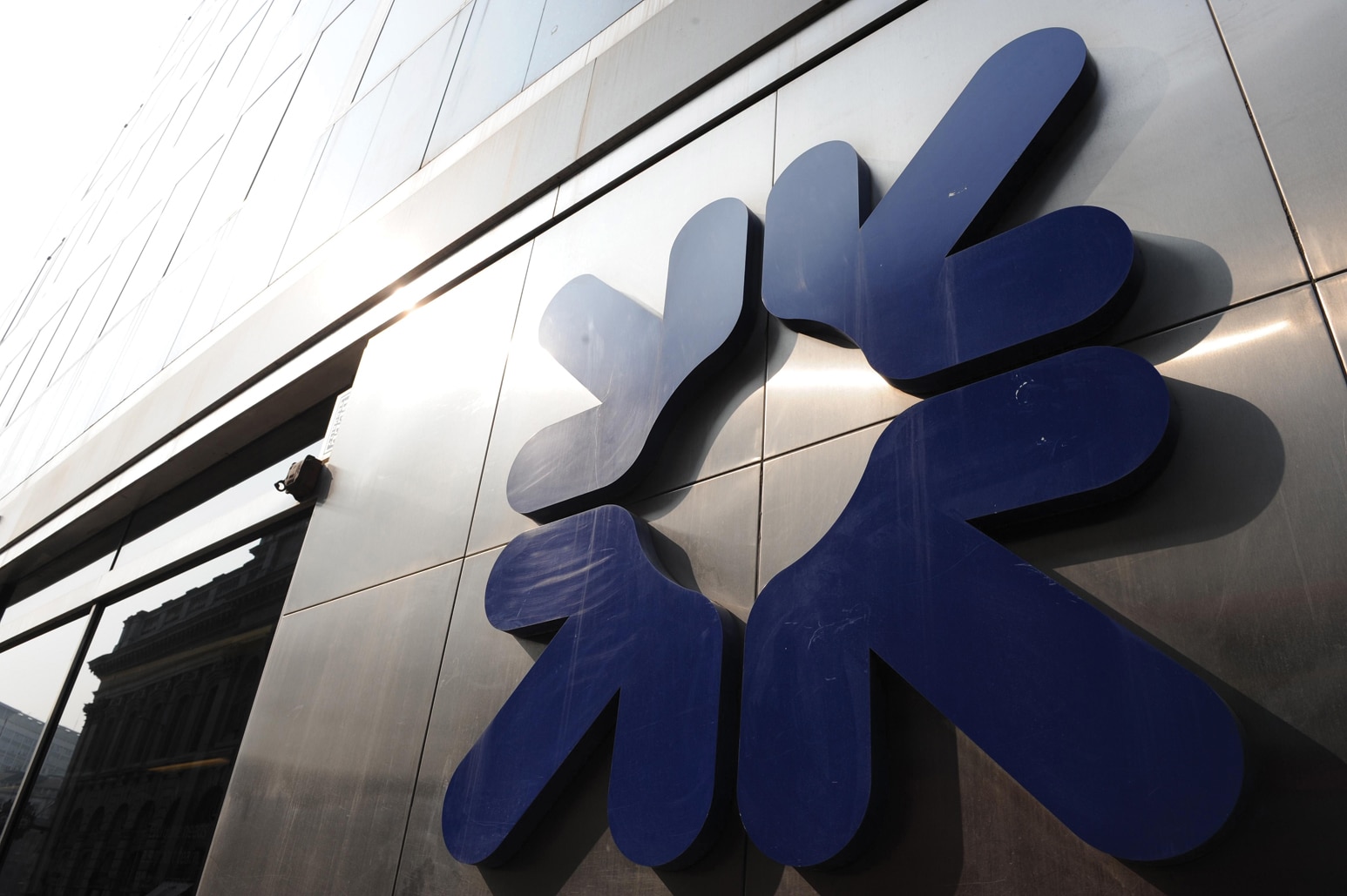 The Royal Bank of Scotland daisy wheel symbol mounted on a glass and steel facade.