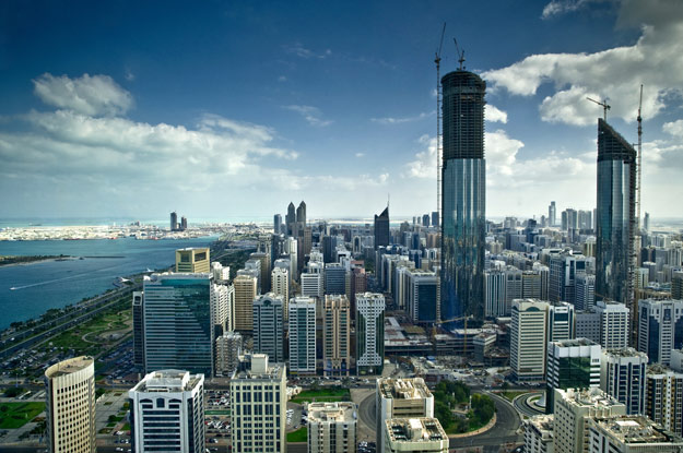 Abu Dhabi's waterfront skyline with towers under construction, illustrating the emirate's rapid development into a nation of brands.