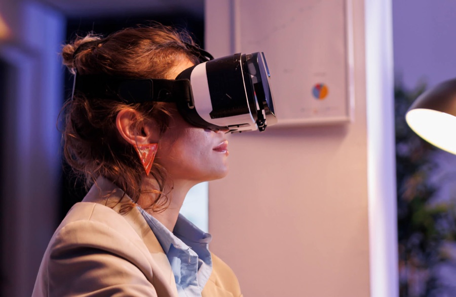 A woman wearing a virtual reality headset in a darkened room | Technology and Innovation
