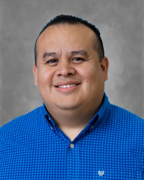 Raul Riojas staff member portrait in blue plaid shirt
