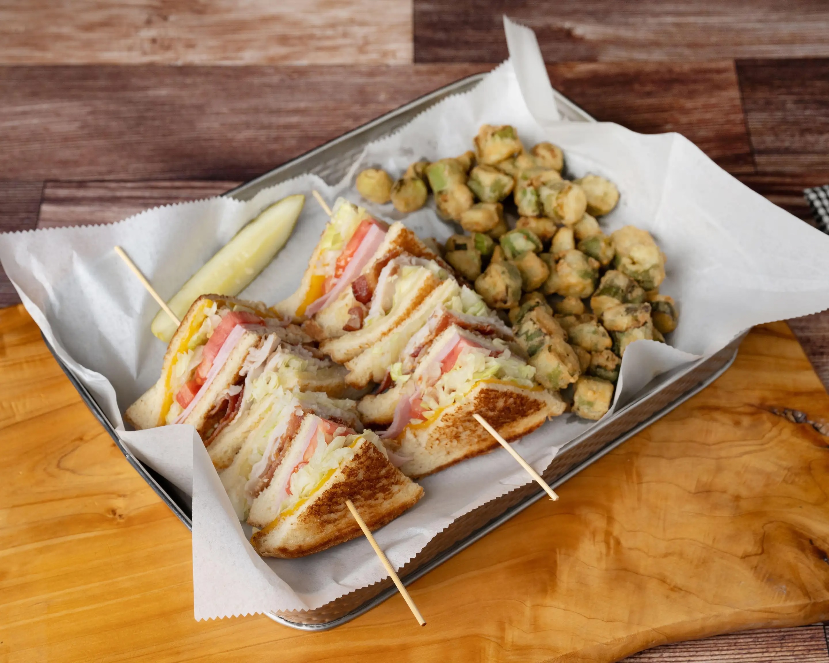 A Triple Decker Club sandwich with a side