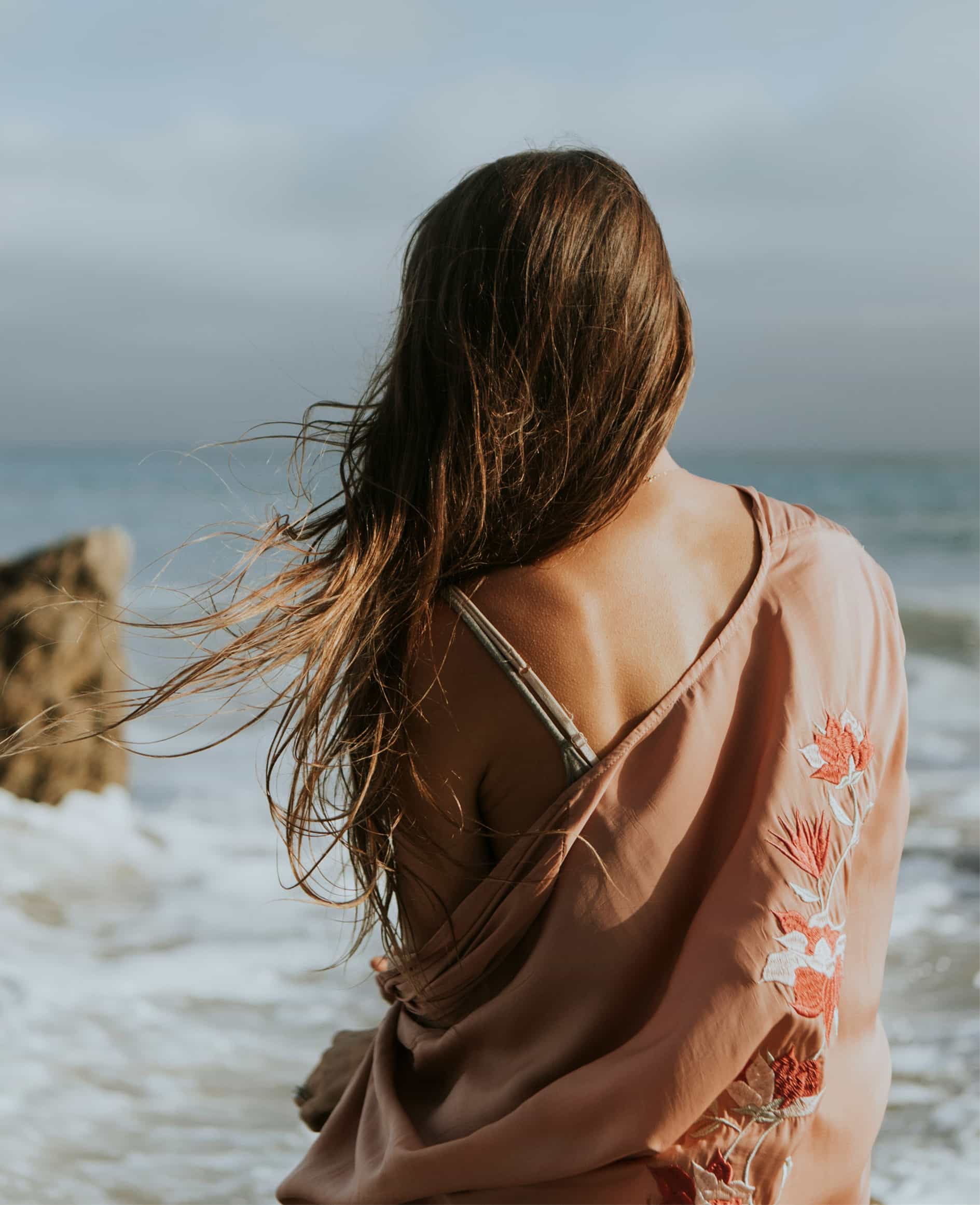 Mujer de espaldas mirando el mar