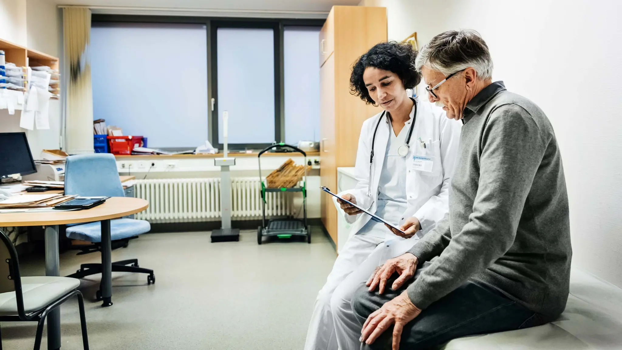 Image of a healthcare provider going over test results on a tablet with a patient in their office