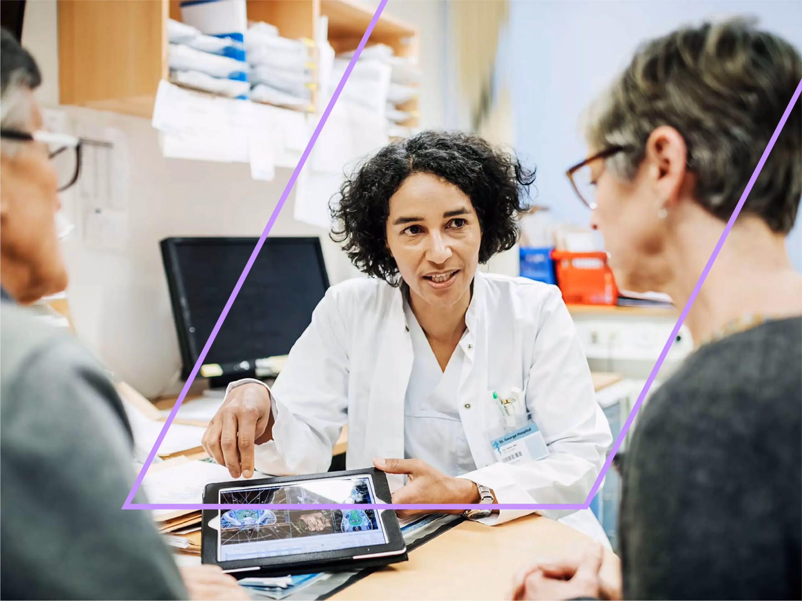 Doctor in a white coat discusses brain scan images on a tablet with two patients seated across the desk.