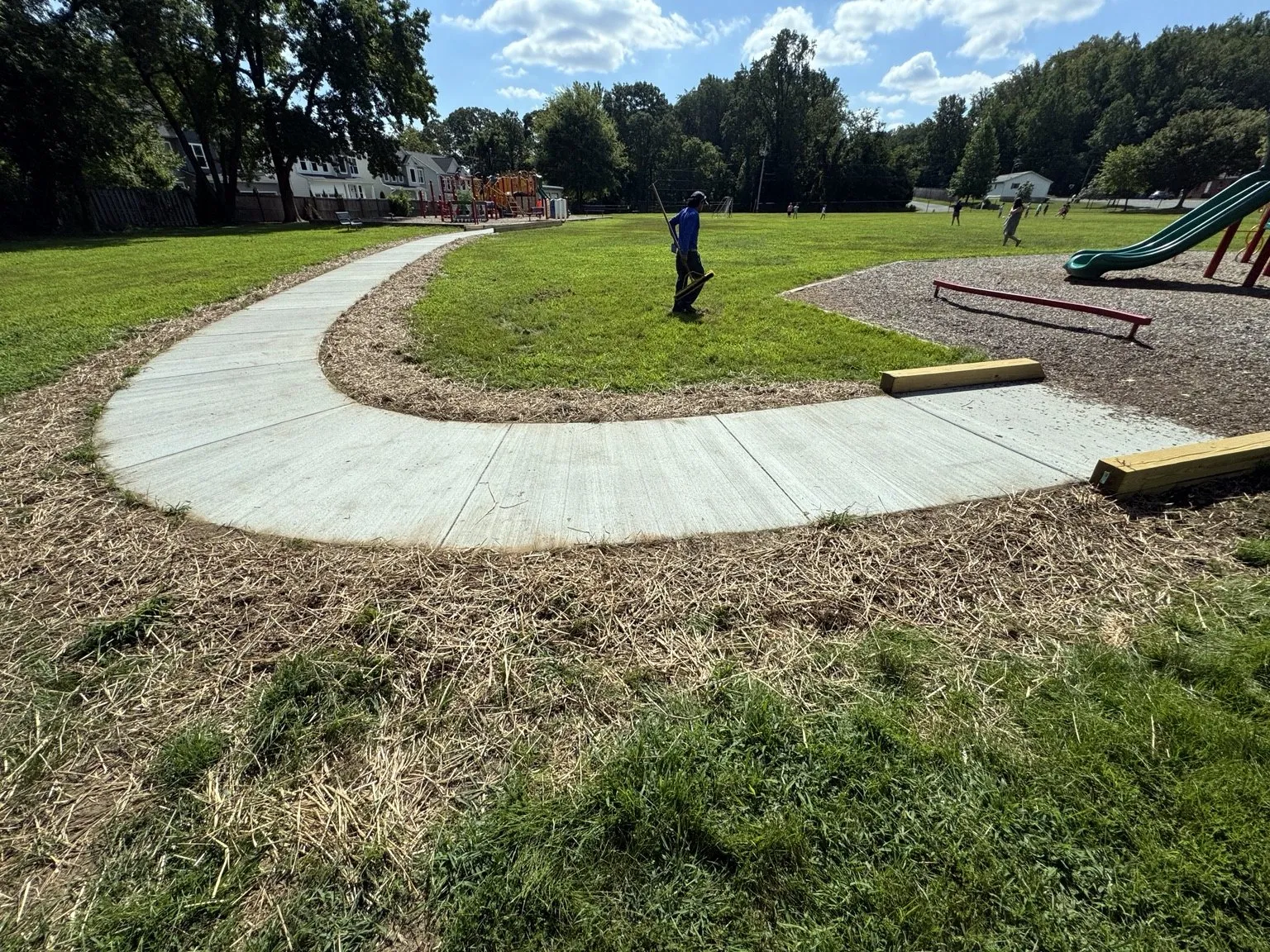 Curved concrete sidewalk completed by CES Construction beside a Maryland playground