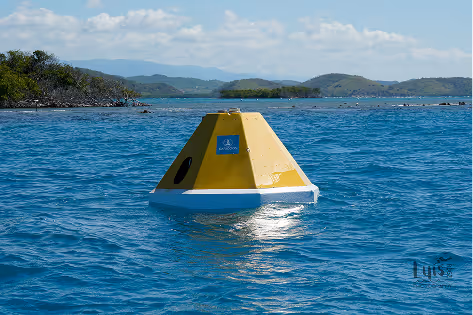 Yellow and white buoy floating on calm blue water with distant green islands under a cloudy sky.