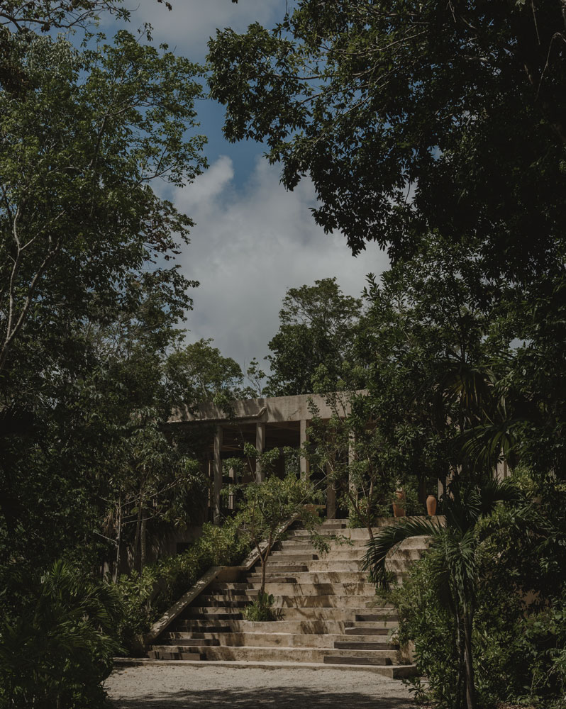 Natural stone pathway winding through lush tropical greenery at La Valise Mazunte Hotel restaurant.