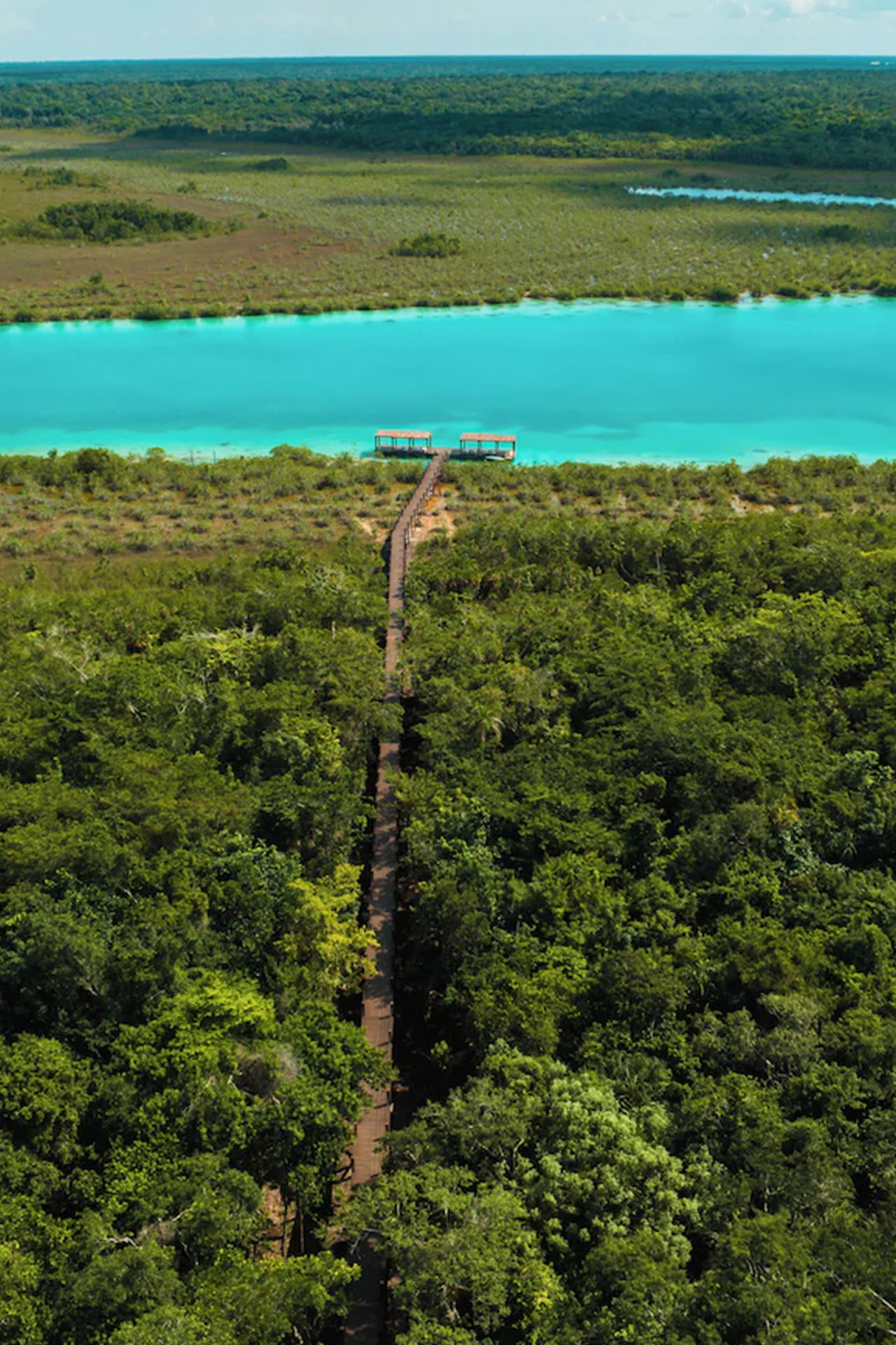 Aerial view of the lush cliffs and pristine beach surrounding the restaurant at La Valise Mazunte Hotel in Mexico.