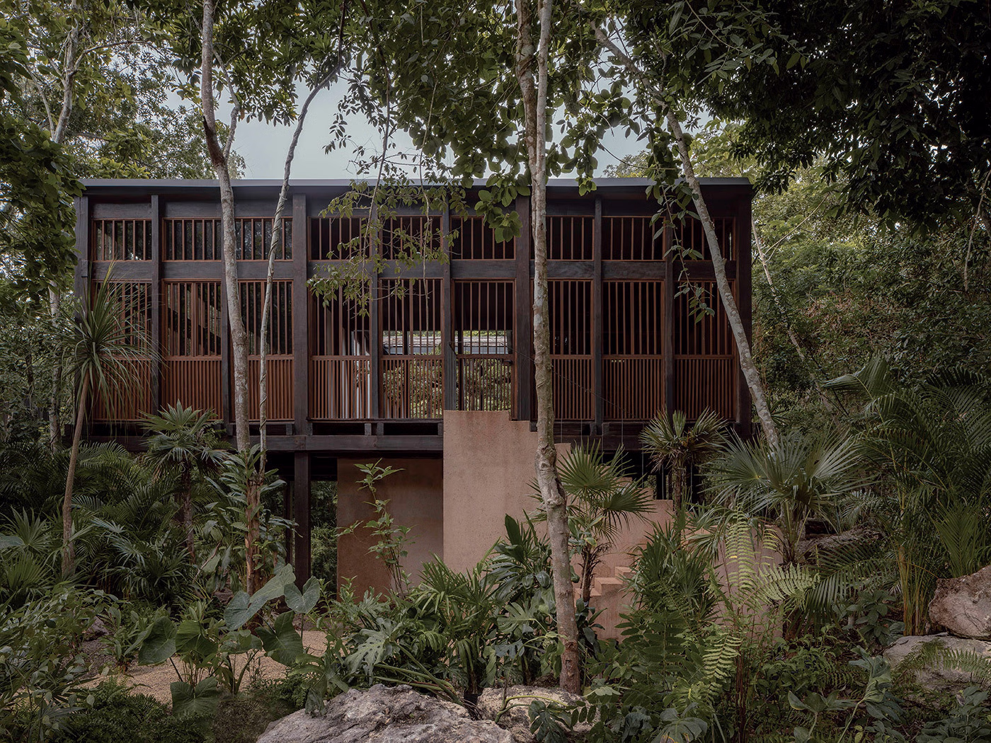 Exterior view of the luxury boutique at La Valise Tulum hotel surrounded by lush tropical jungle in Mexico.