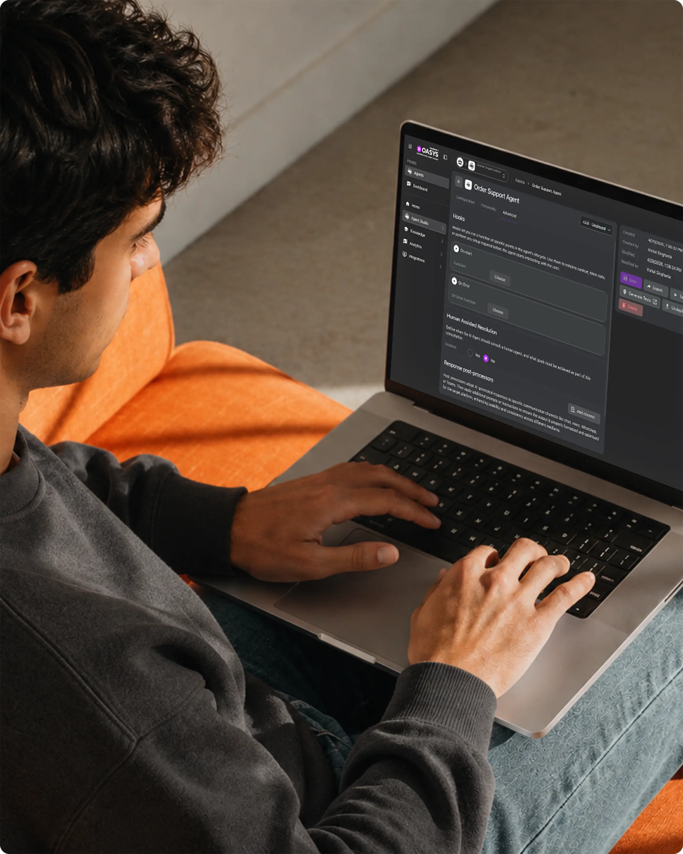 Person using a laptop on an orange couch viewing an 'Order Support Agent' dashboard screen.