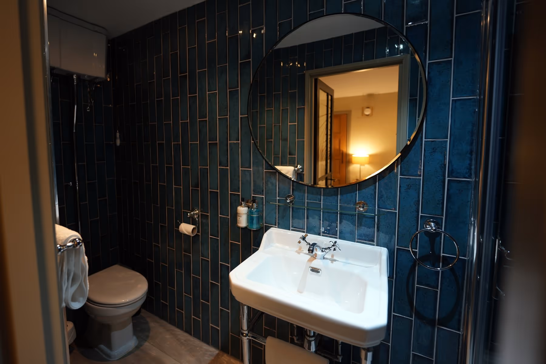 Double Room bathroom at Riva Helensburgh with white metro tile walls, a walk-in rainfall shower, chrome fixtures, and Highland Soap toiletries.