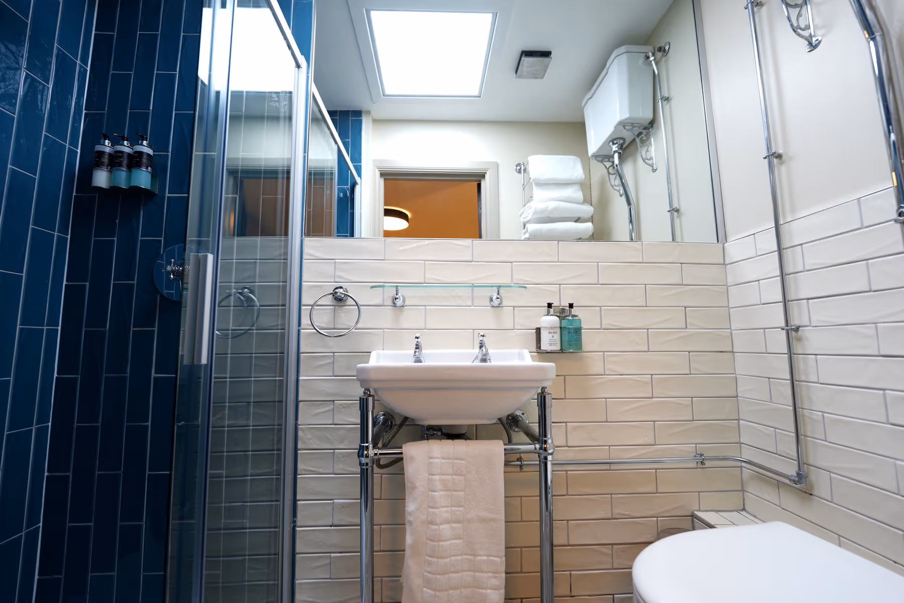 Twin Room en-suite bathroom at Riva Helensburgh showing white metro tiles, chrome fixtures, and a walk-in shower.