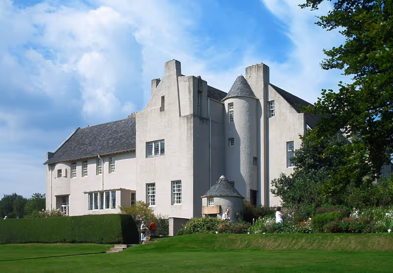 The Hill House in Helensburgh, Charles Rennie Mackintosh's iconic Arts and Crafts masterpiece, showing the white harled exterior with turret and manicured gardens.