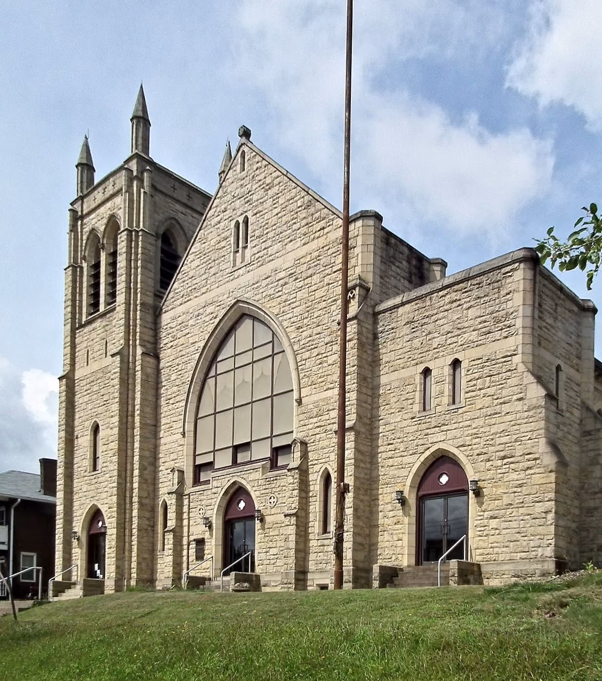 A photo of New Life from N. Freemont Street. The gothic sandstone building sits on a small grassy hill.