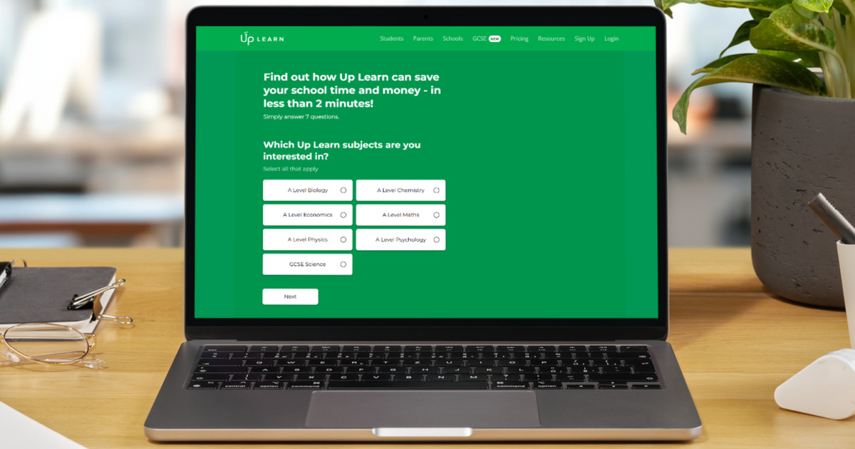 A laptop on a desk with screenshot showing Up Learn's ROI calculator